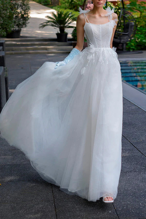 A simple wedding dress with thin shoulder straps, spoonful beads, and a single thread